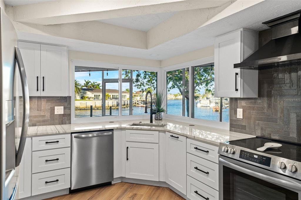 4968 South Shore Drive New Port Richey, FL 34652 - Photo 6 of 60 a kitchen with white cabinets and appliances