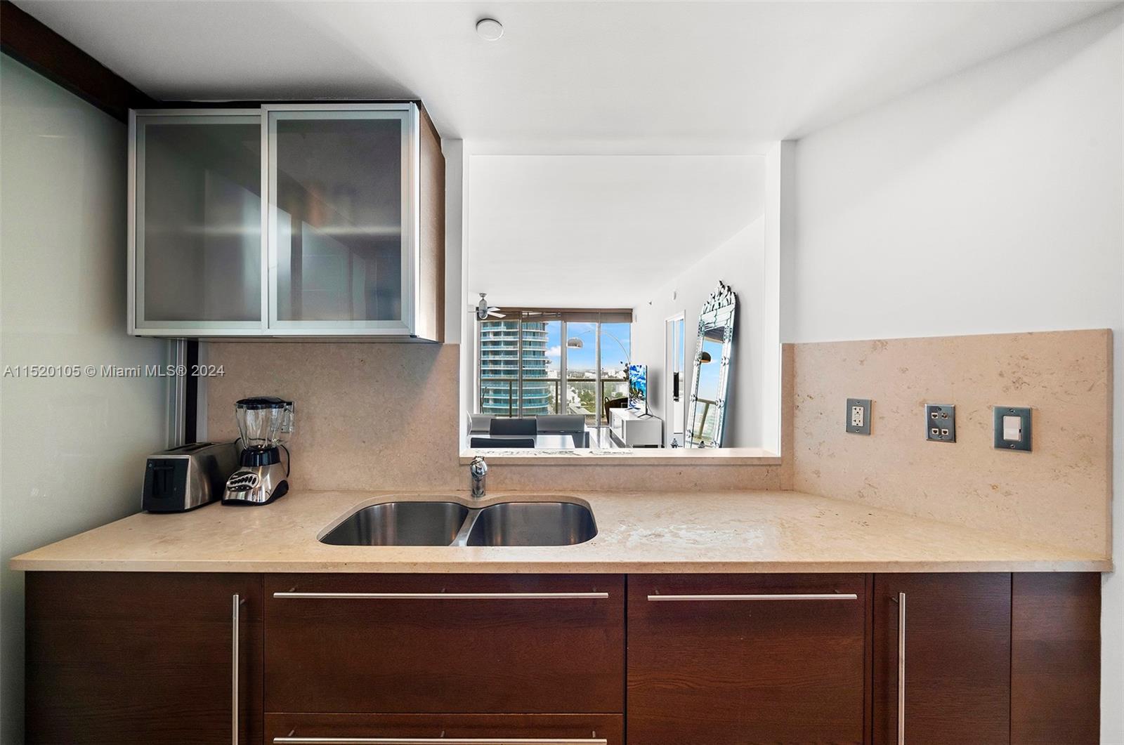 450 Alton Road, Unit 2006 Miami Beach, FL 33139 - Photo 11 of 51 a kitchen with a sink and a refrigerator
