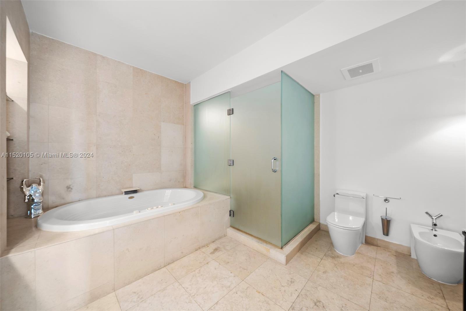 450 Alton Road, Unit 2006 Miami Beach, FL 33139 - Photo 22 of 51 a spacious bathroom with a bathtub and toilet