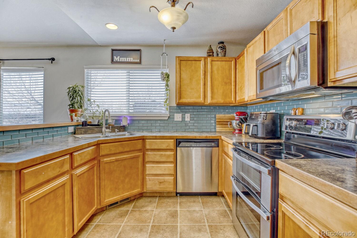 2179 Fletcher Avenue Brighton, CO 80603 - Photo 11 of 29 a kitchen with stainless steel appliances granite countertop a sink stove and cabinets