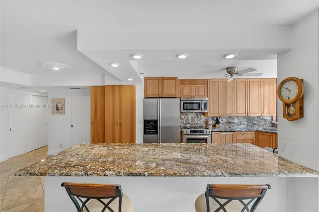 a kitchen with stainless steel appliances granite countertop a sink and a refrigerator