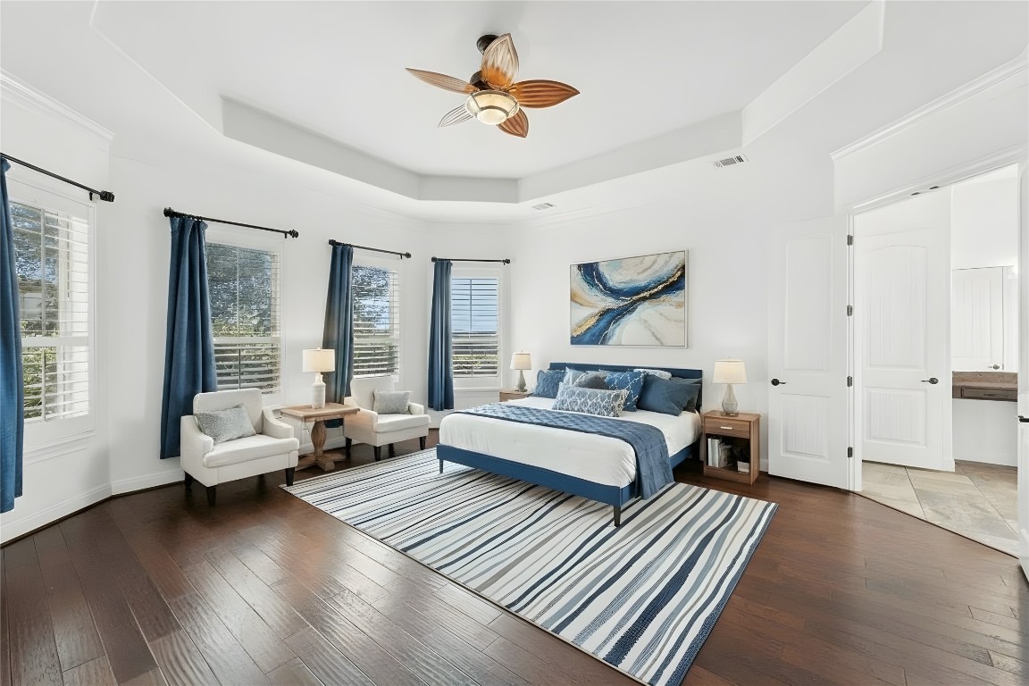 15729 De Fortuna Drive Bee Cave, TX 78738 - Photo 15 of 40 Bedroom featuring a tray ceiling, dark wood-style flooring, and a ceiling fan