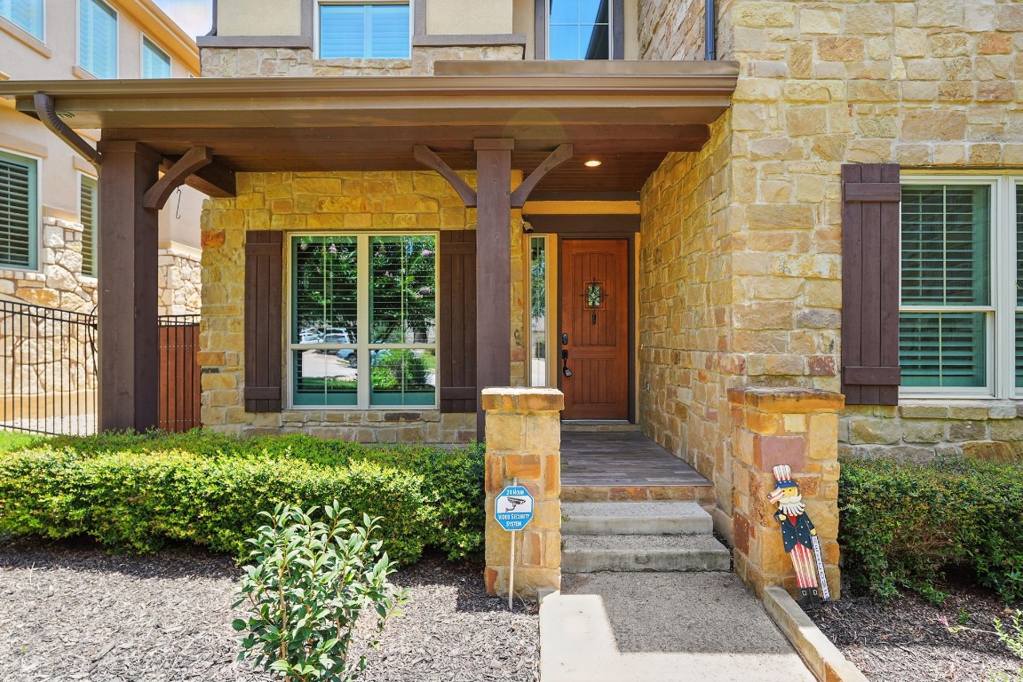 15729 De Fortuna Drive Bee Cave, TX 78738 - Photo 2 of 40 Doorway to property featuring stone siding and covered porch