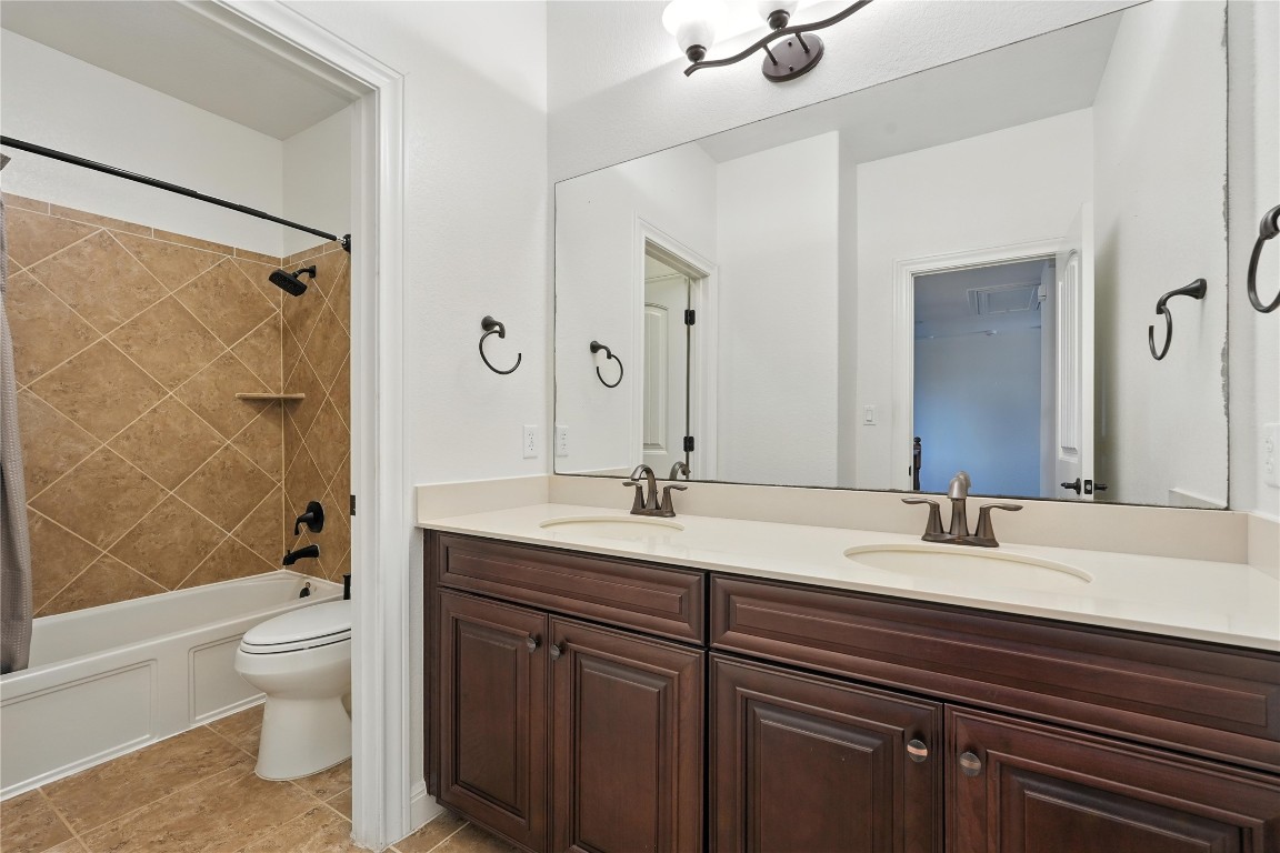 15729 De Fortuna Drive Bee Cave, TX 78738 - Photo 31 of 40 a bathroom with a granite countertop sink toilet a large mirror and shower