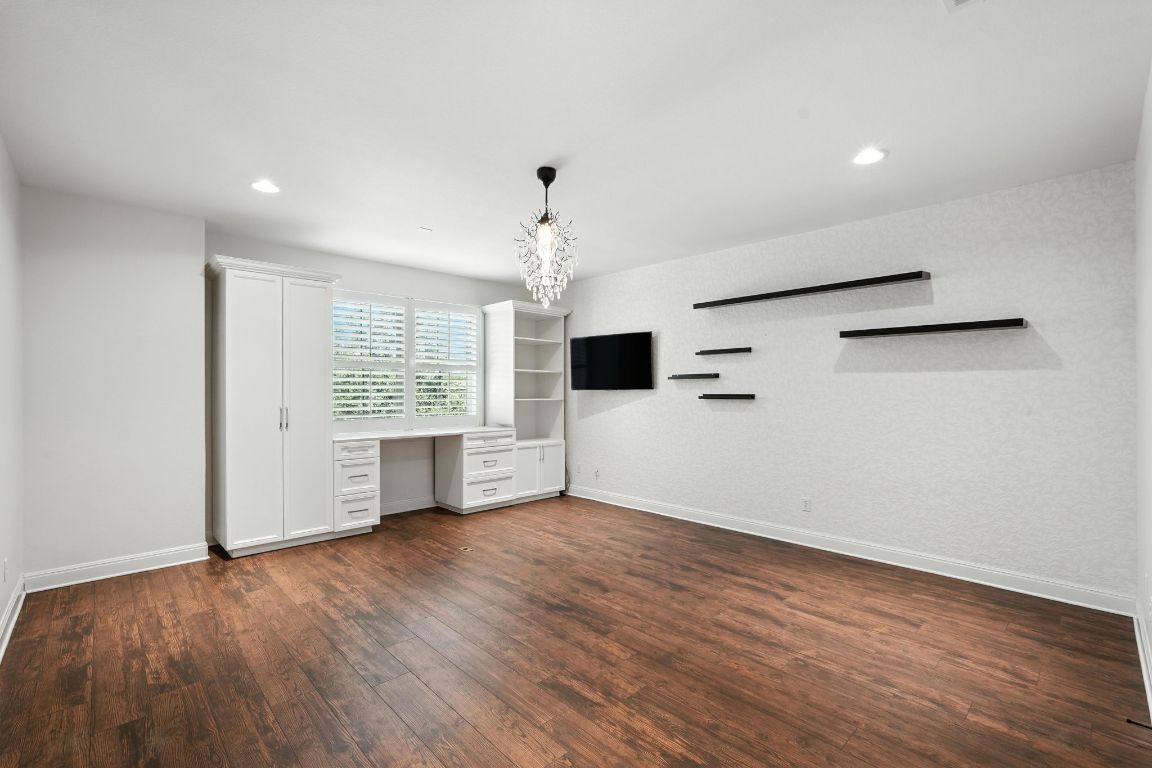 15729 De Fortuna Drive Bee Cave, TX 78738 - Photo 34 of 40 Unfurnished living room featuring built in desk, dark wood-type flooring, and recessed lighting
