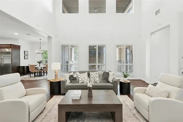 a kitchen with stainless steel appliances granite countertop a stove a refrigerator a oven a sink a dining table and chairs with wooden floor