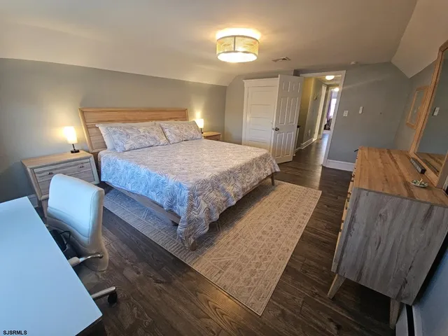 a bedroom with a bed with wooden floor