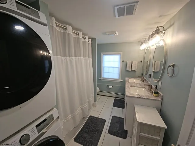 a bathroom with a sink a toilet a mirror and shower