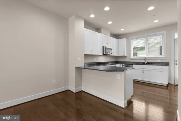 a kitchen with granite countertop white cabinets and a stove