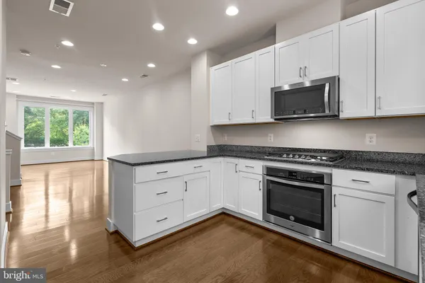 a kitchen with granite countertop stainless steel appliances a refrigerator and a sink