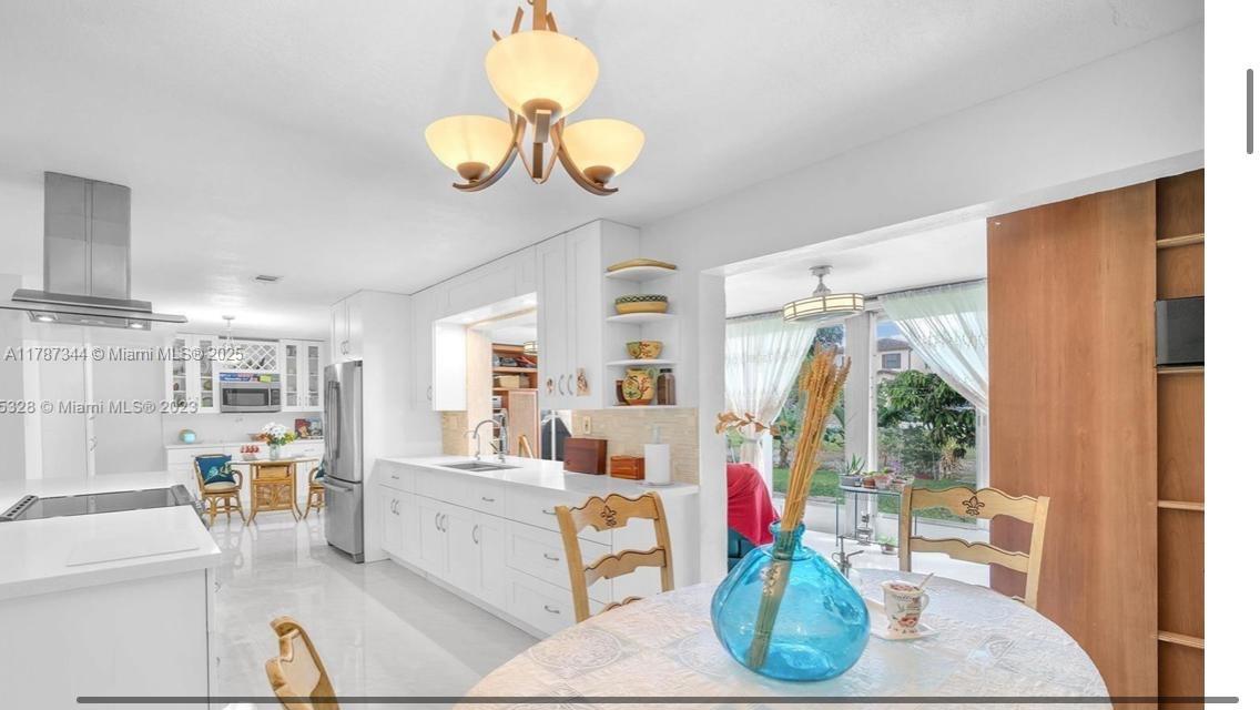 4941 Northwest 55th Court Tamarac, FL 33319 - Photo 11 of 30 a living room with furniture chandelier and a large window