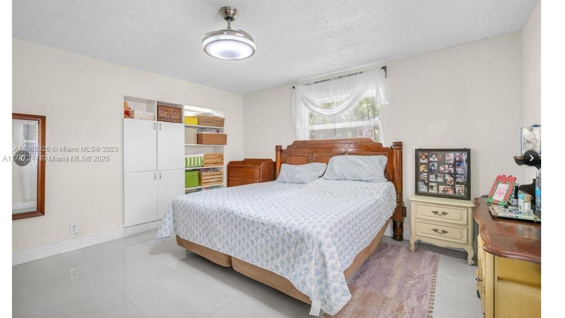 4941 Northwest 55th Court Tamarac, FL 33319 - Photo 19 of 30 a bedroom with a bed and cabinets