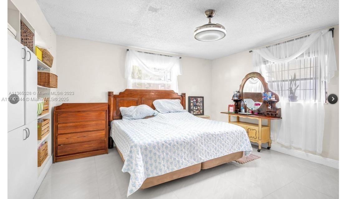 4941 Northwest 55th Court Tamarac, FL 33319 - Photo 20 of 30 a bedroom with a bed and a dresser with mirror