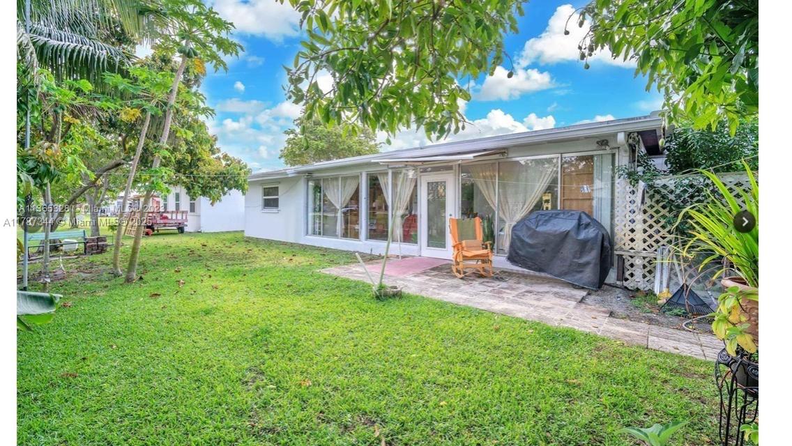 4941 Northwest 55th Court Tamarac, FL 33319 - Photo 29 of 30 a view of a house with a backyard and a patio