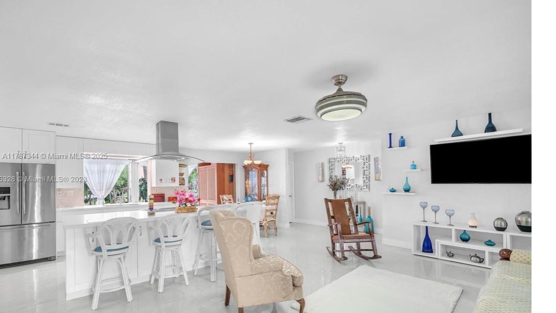 4941 Northwest 55th Court Tamarac, FL 33319 - Photo 4 of 30 a living room with furniture a flat screen tv and kitchen view