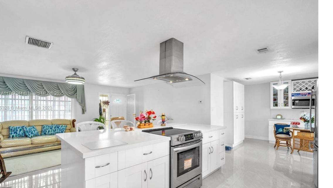 4941 Northwest 55th Court Tamarac, FL 33319 - Photo 6 of 30 a kitchen with a sink stove and cabinets