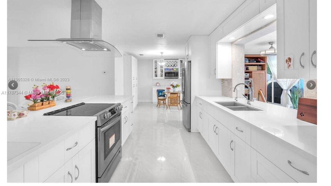 4941 Northwest 55th Court Tamarac, FL 33319 - Photo 8 of 30 a large white kitchen with a sink a stove and a refrigerator