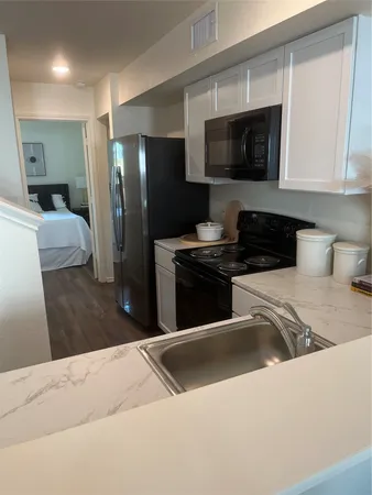 a kitchen with stainless steel appliances kitchen island granite countertop a refrigerator and a stove top oven