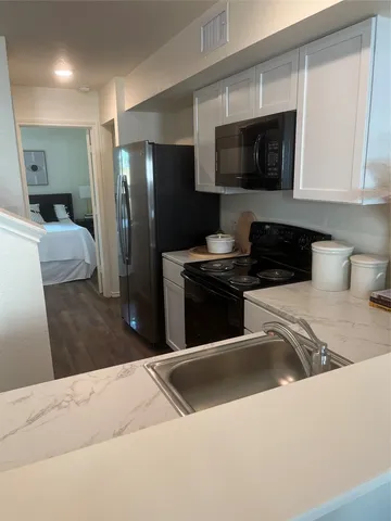 a kitchen with stainless steel appliances kitchen island granite countertop a refrigerator and a stove top oven