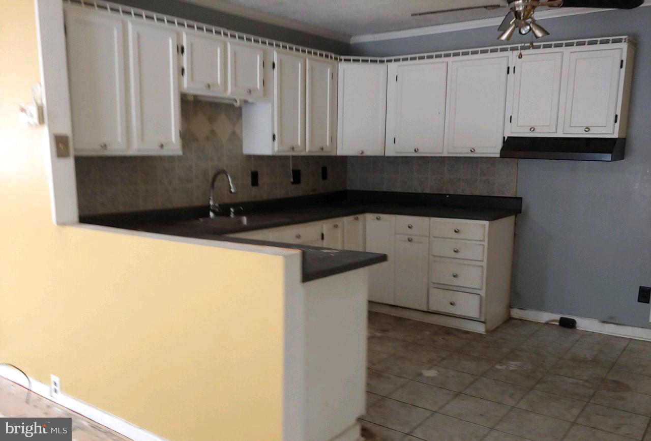 1305 2nd Road Baltimore, MD 21220 - Photo 4 of 6 a kitchen with granite countertop white cabinets and stainless steel appliances