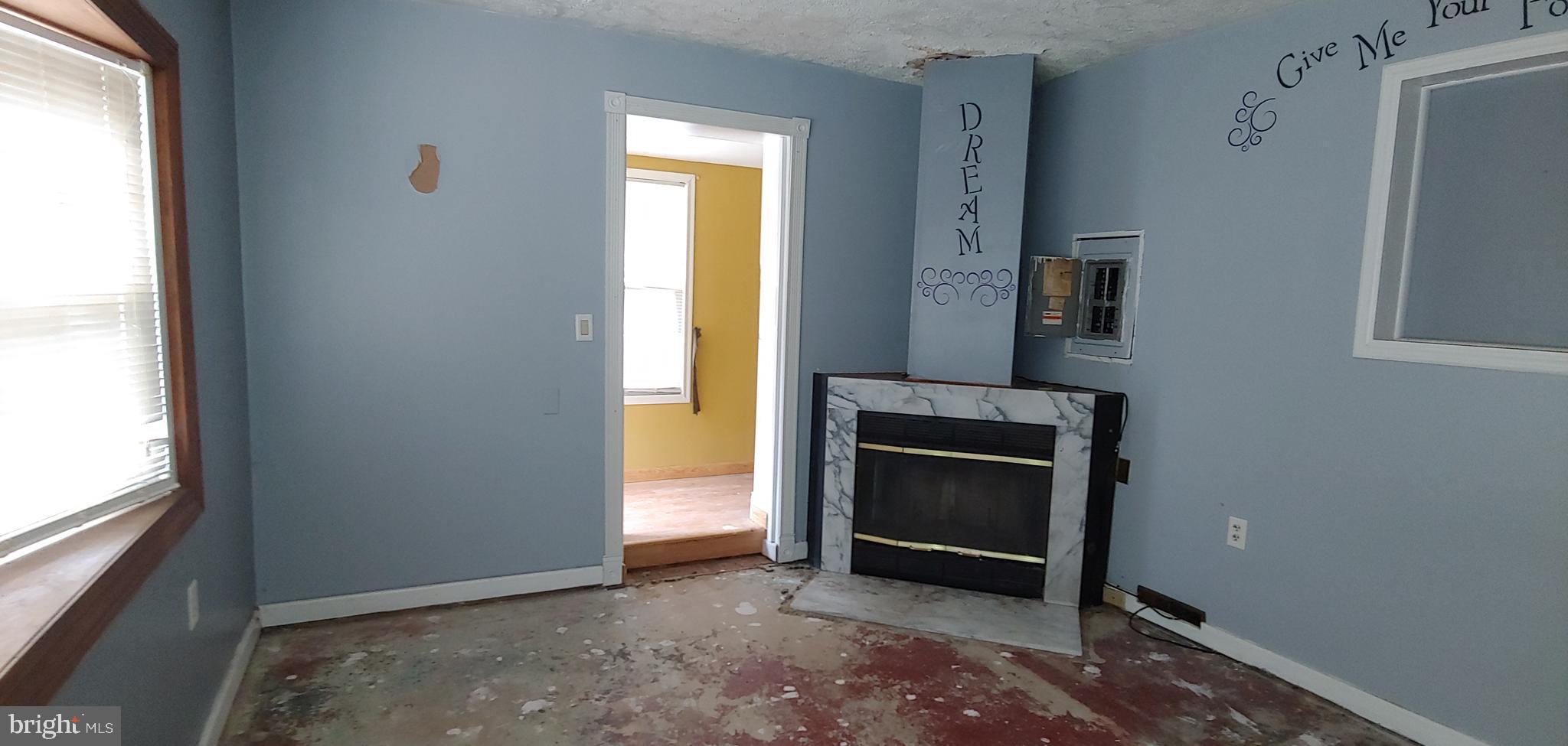 1305 2nd Road Baltimore, MD 21220 - Photo 6 of 6 a view of an empty room with a fireplace and a window