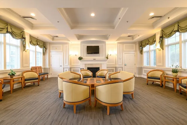 a living room with couches a large dining table and chairs with wooden floor