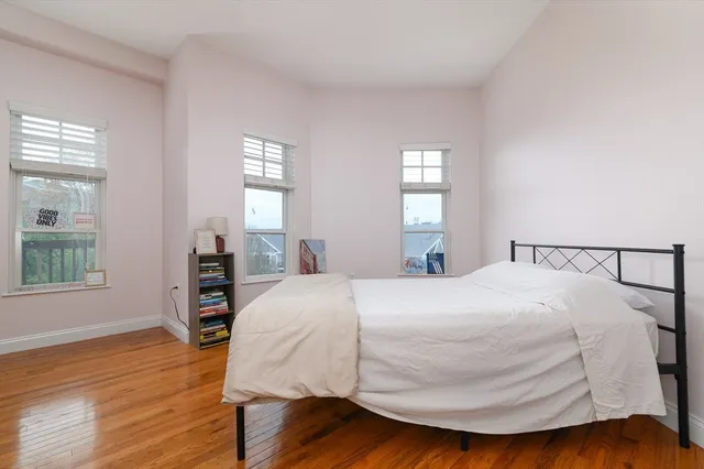 a bedroom with a bed and wooden floor