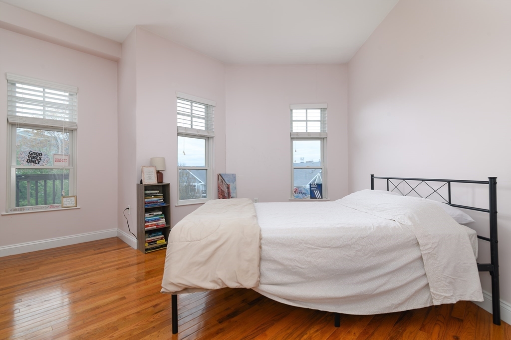 501 Commerce Drive, Unit 2310 Braintree, MA 02184 - Photo 10 of 23 a bedroom with a bed and wooden floor