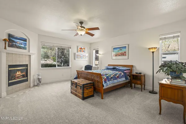 a spacious bedroom with a bed a couch and paintings on the wall
