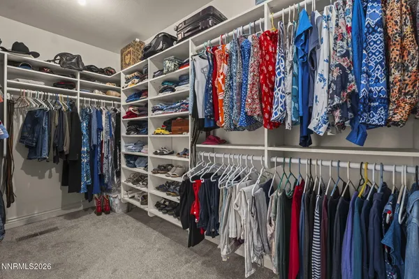 a view of walk in closet with clothes and shoes