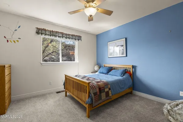 a bed sitting in a bedroom next to a window