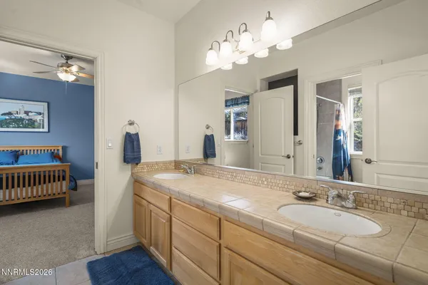 a spacious bathroom with a granite countertop sink and a mirror