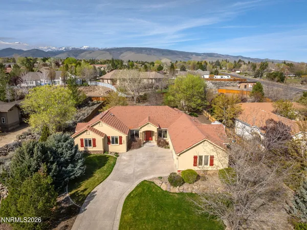 an aerial view of residential houses with outdoor space and trees