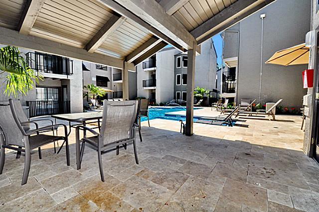 6910 Skillman Street, Unit 2016 Dallas, TX 75231 - Photo 20 of 23 a view of a patio with table and chairs potted plants with wooden floor