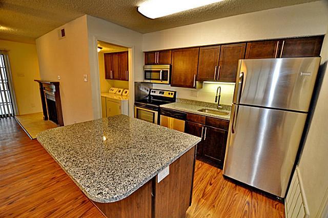 6910 Skillman Street, Unit 2016 Dallas, TX 75231 - Photo 2 of 23 a kitchen with granite countertop a refrigerator and a sink