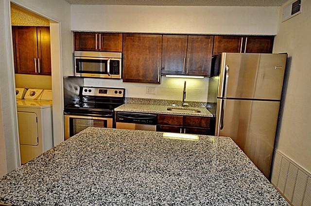 6910 Skillman Street, Unit 2016 Dallas, TX 75231 - Photo 3 of 23 a kitchen with stainless steel appliances a refrigerator and a stove top oven