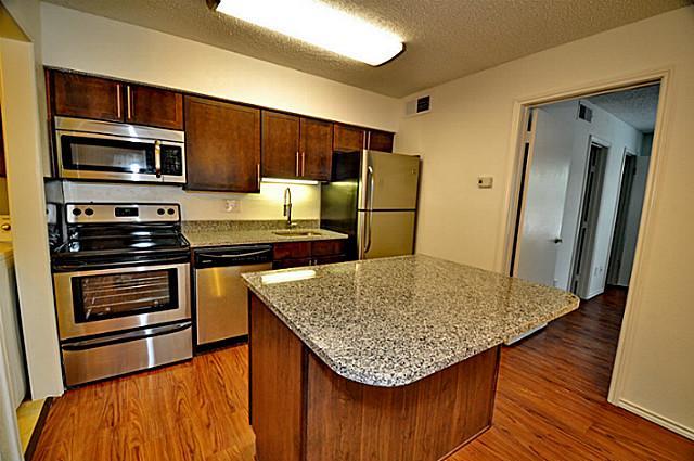 6910 Skillman Street, Unit 2016 Dallas, TX 75231 - Photo 5 of 23 a kitchen with stainless steel appliances granite countertop a sink refrigerator and microwave