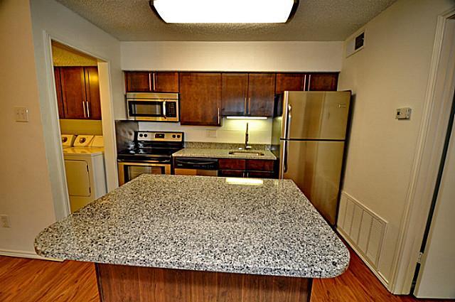 6910 Skillman Street, Unit 2016 Dallas, TX 75231 - Photo 8 of 23 a kitchen with a refrigerator and a stove top oven