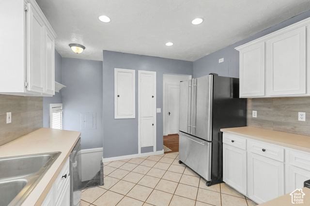 154 South State Street Morgan, UT 84050 - Photo 3 of 25 White cabinetry with dark hardware, a stainless steel refrigerator, tile flooring, and a light-toned countertop