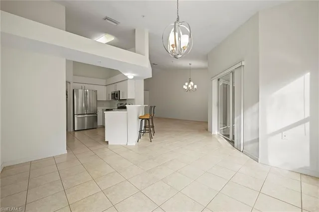 a view of a kitchen with furniture and refrigerator