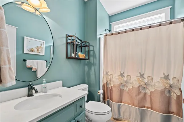 a bathroom with a sink vanity mirror and toilet