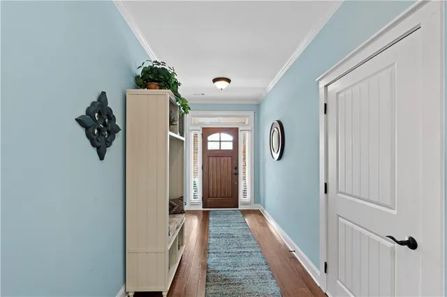 a view of hallway with stairs and wooden floor