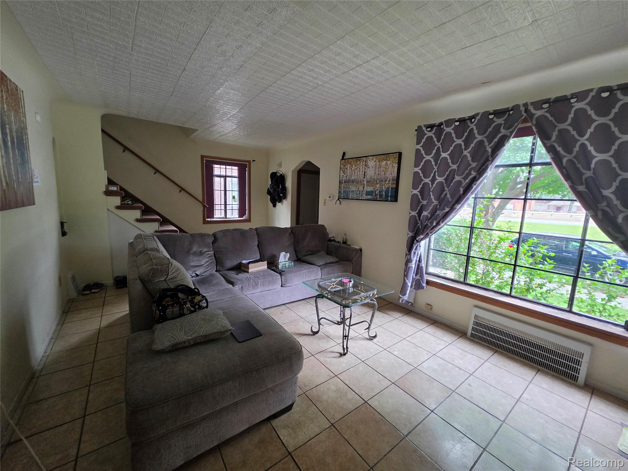 15832 Griggs Street Detroit, MI 48238 - Photo 9 of 24 Living area featuring tiled flooring, a large multi-pane window, and a textured ceiling