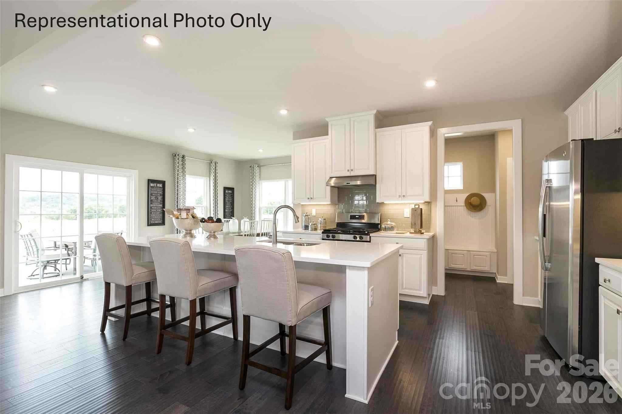 2023 Grain Orchard Road Indian Trail, NC 28079 - Photo 3 of 12 a kitchen with stainless steel appliances a dining table chairs a refrigerator and cabinets