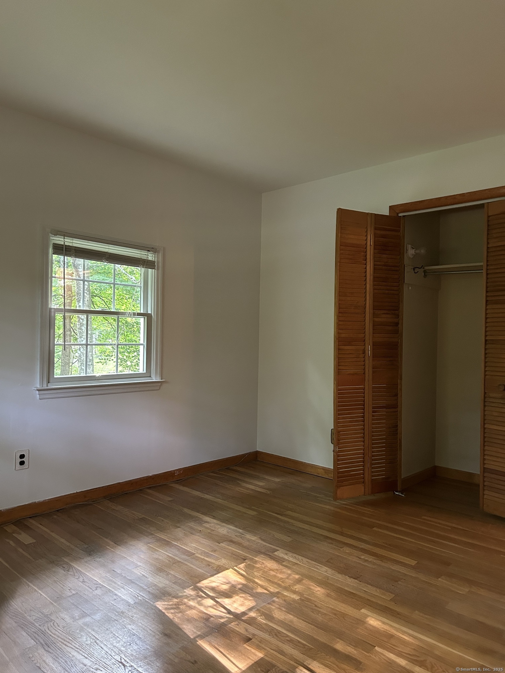 14 Aspen Ledges Road Ridgefield, CT 06877 - Photo 18 of 19 an empty room with wooden floor and windows
