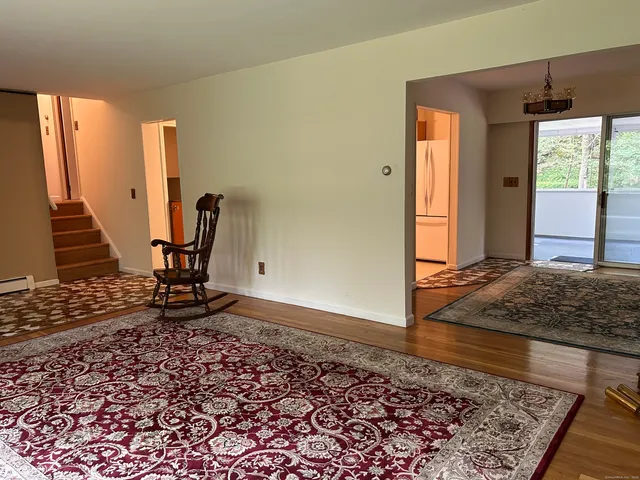 a view of a hallway with wooden floor and a rug