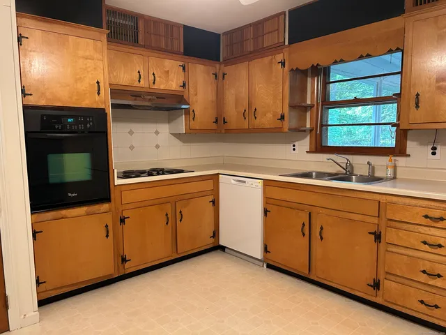 a kitchen with granite countertop cabinets stainless steel appliances and a sink