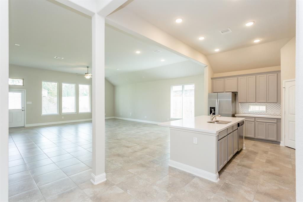 a large white kitchen with a sink and cabinets