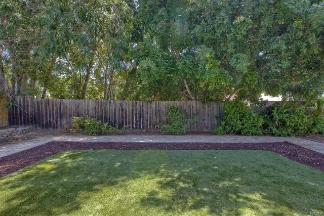 a view of a yard with wooden fence