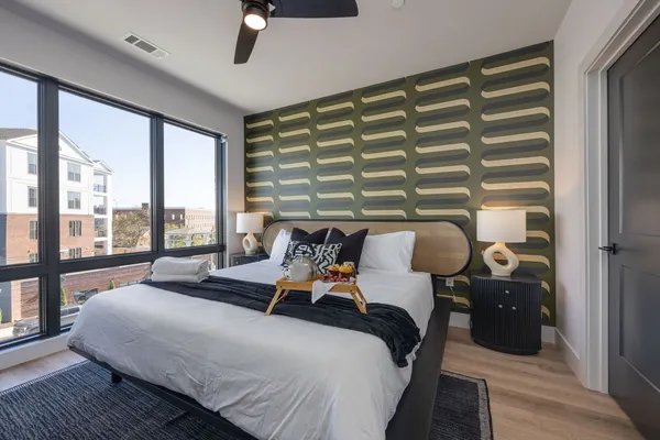 a bedroom with a bed and large windows